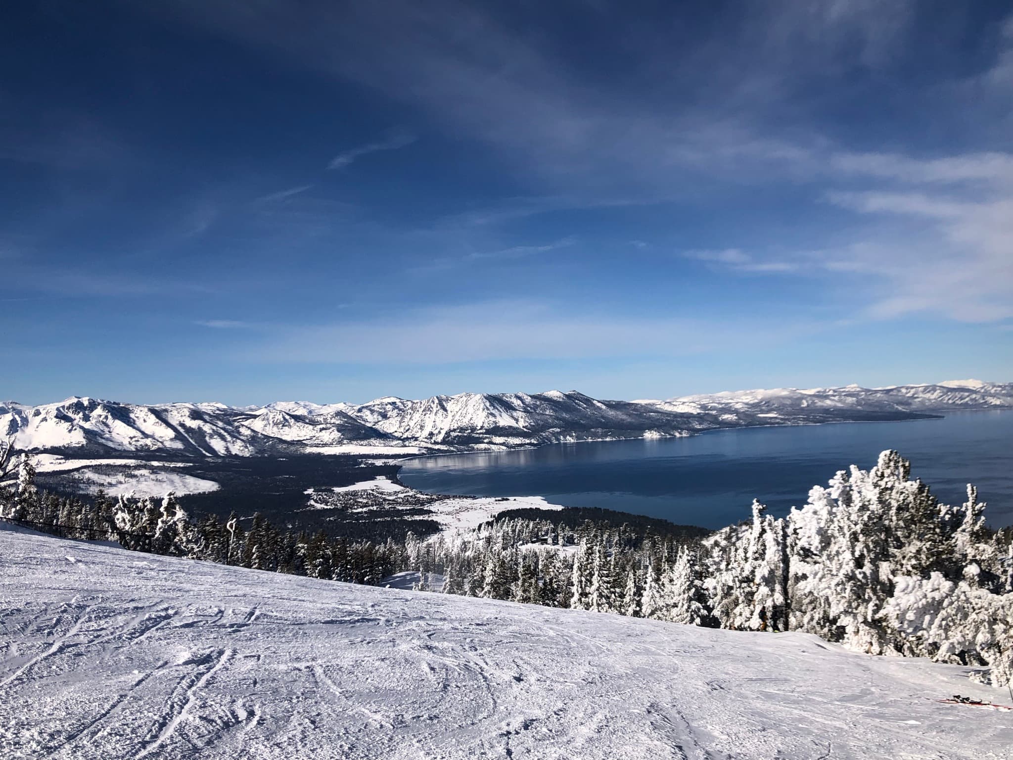 Snow-covered mountains and Lake Tahoe seen from high above Heavenly
